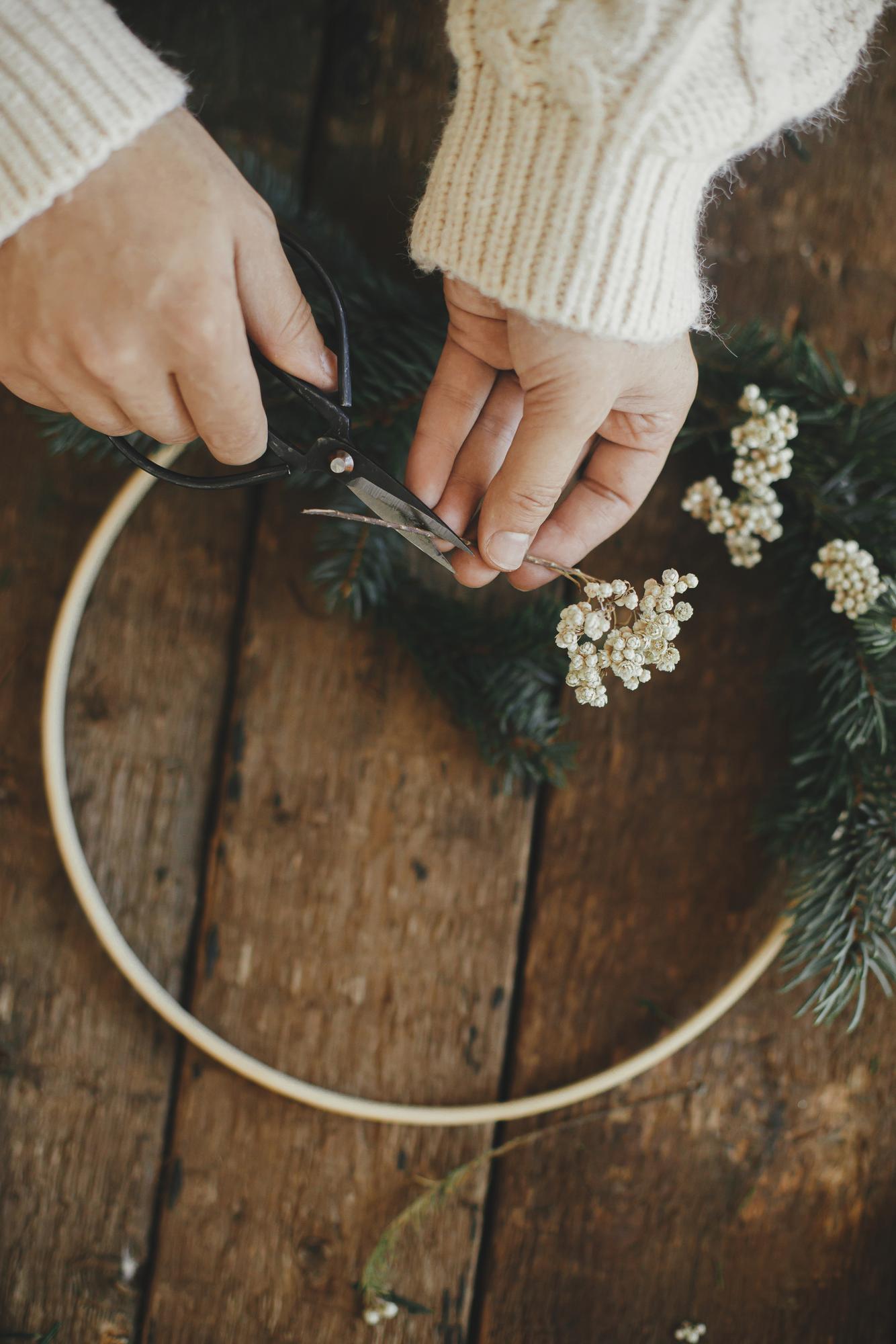 Workshop hands holding embroidered hoop with floral design